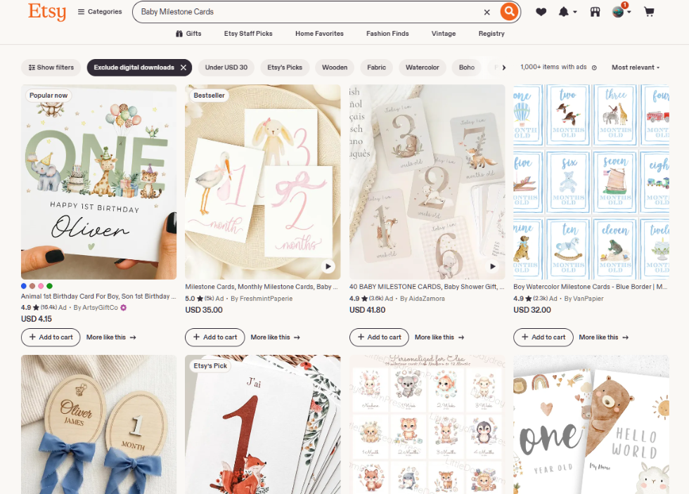 Etsy搜索baby milestone cards的结果页,显示1000多件带广告的商品,售价从4.15美元到41.80美元不等,风格包括水彩动物、木质圆牌、蓝色边框插画等