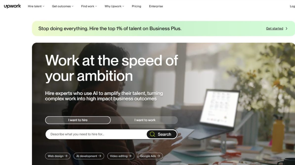 Upwork官网首页，标语Work at the speed of your ambition，页面有I want to hire和I want to work两个入口和搜索框