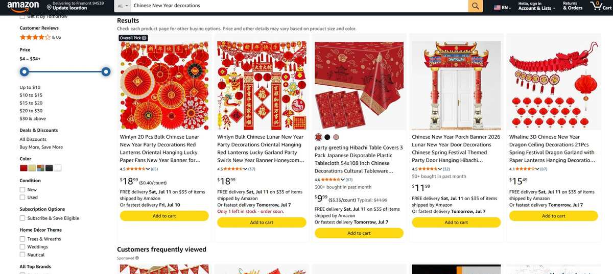 亚马逊搜索Chinese New Year decorations的结果页，20件套灯笼纸扇18.99美元、桌布3件装9.99美元近一个月300多人买过、门廊横幅11.99美元50多人买过